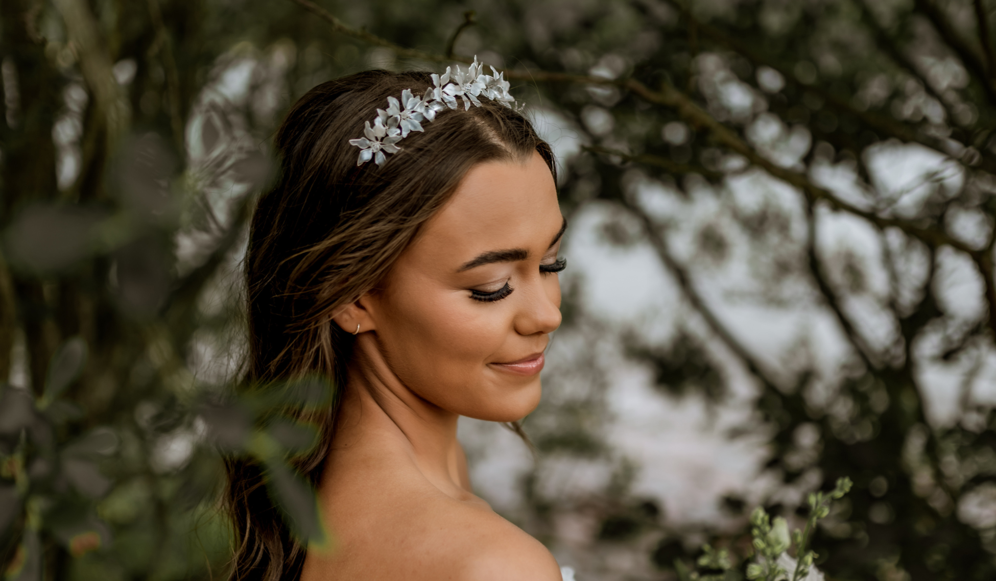 woman surrounded by trees wearing a hand-painted floral tiara